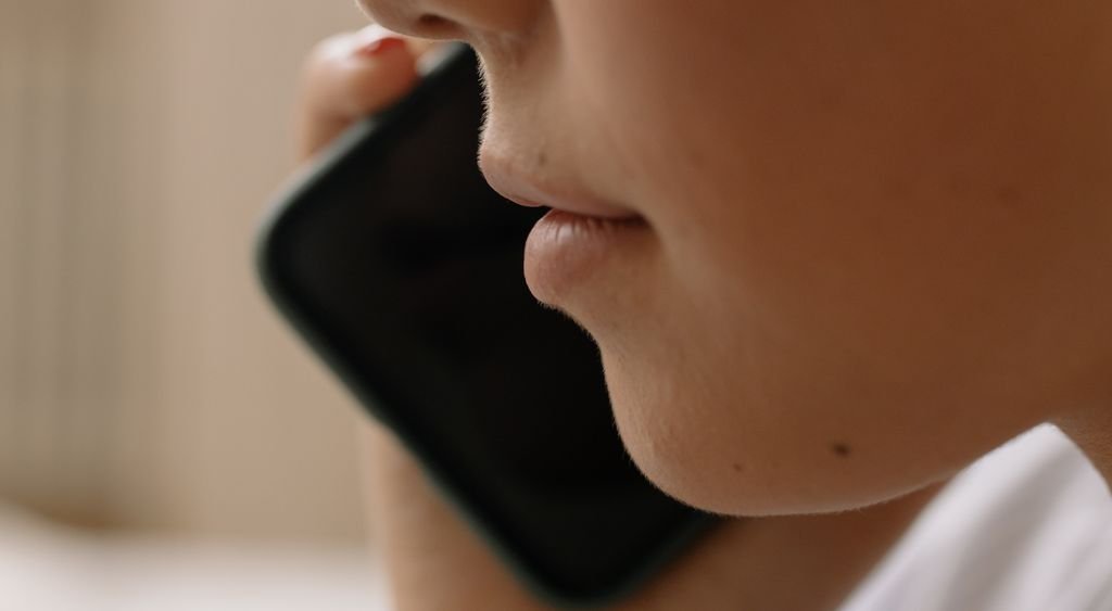 Gros plan sur une personne tenant son téléphone contre l'oreille pendant un appel