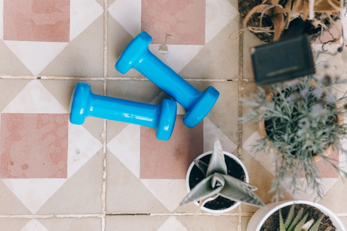 A pair of dumbbells on a tiled floor at home