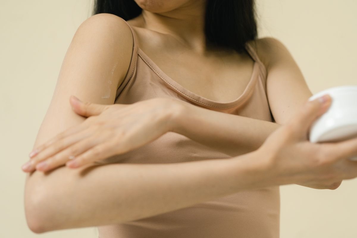 Woman smoothing body cream onto her arm