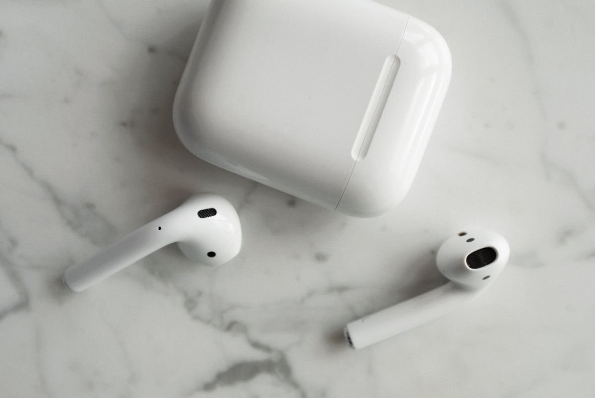 Kabellose In-Ear-Kopfhörer mit Ladecase auf einer Marmorfläche