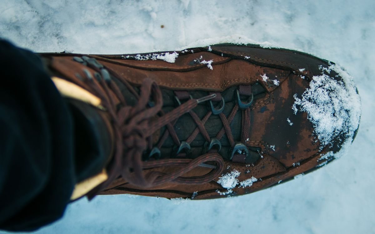 Close-up of a leather lace-up boot on a snowy path
