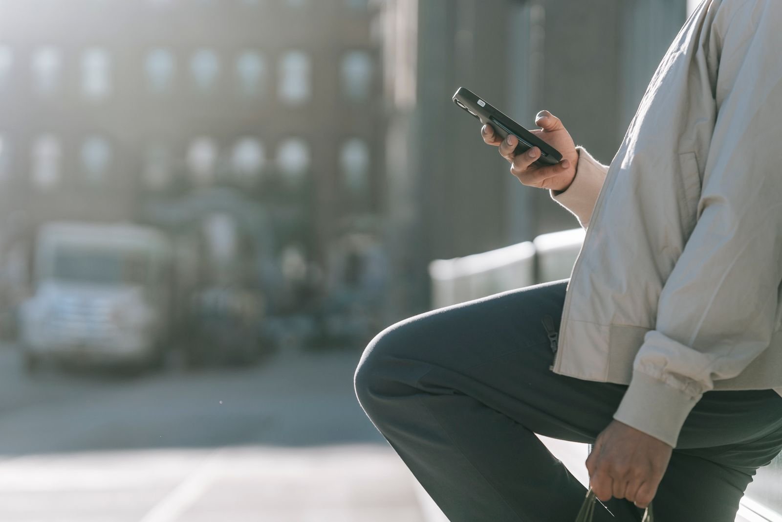Phone held in one hand while sitting on a city step