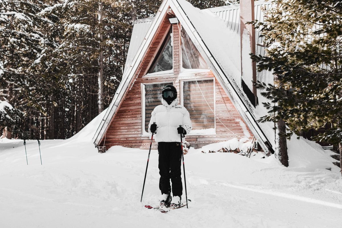 Sciatrice davanti a una baita nella neve