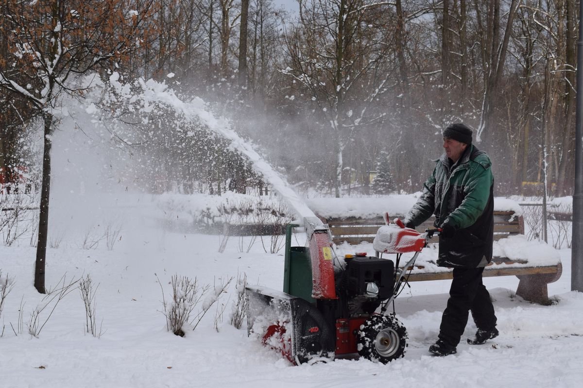 Snow thrower throwing snow in a winter park